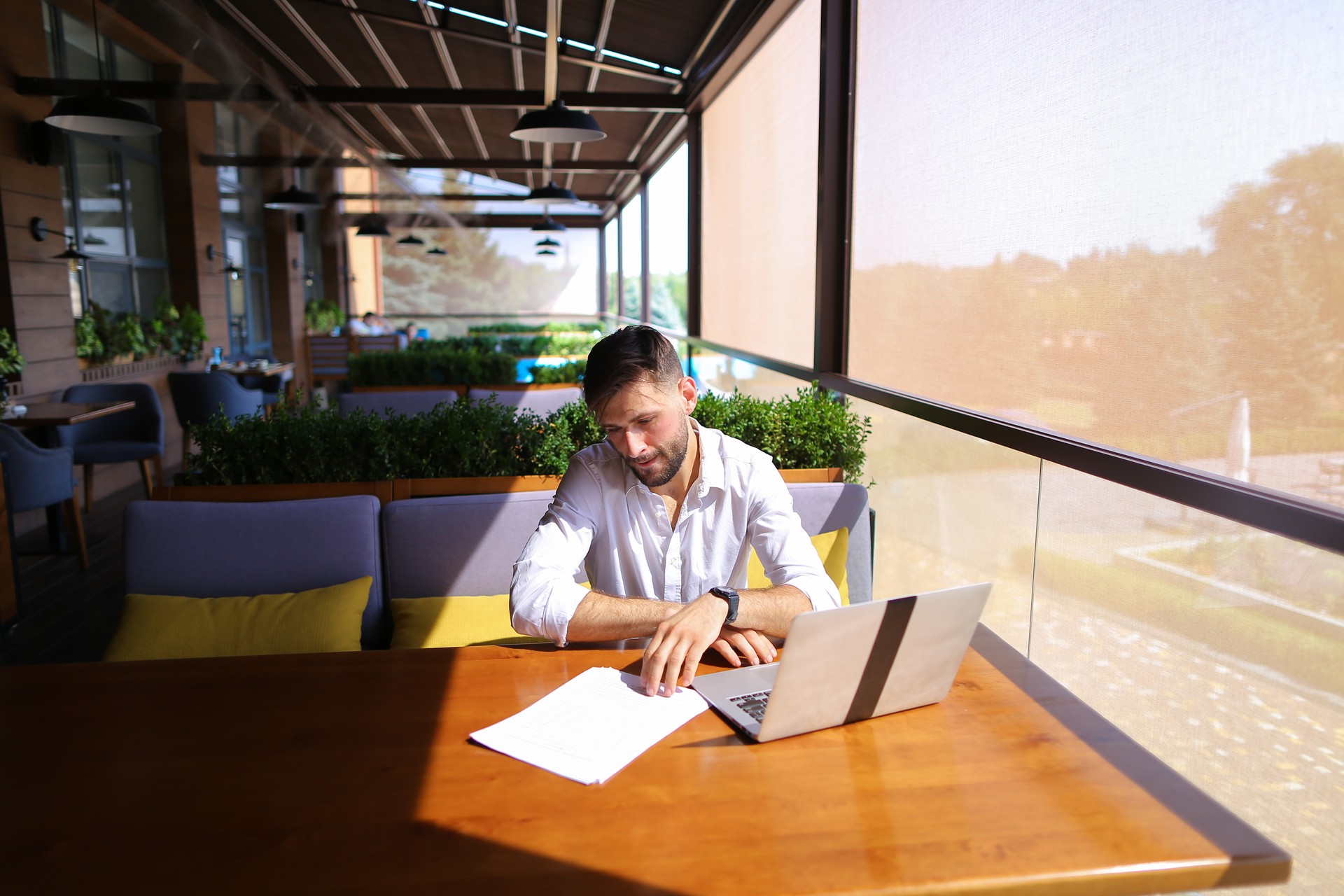 Copywriter typing text on laptop at cafe table